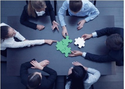 Team Solving Jigsaw Puzzle On Table